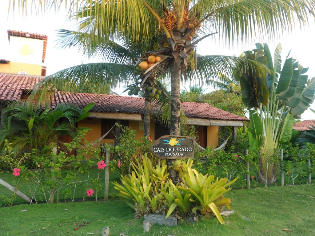 uma palmeira com um sinal em frente a uma casa em Cais Dourado Pousada em Barra Grande