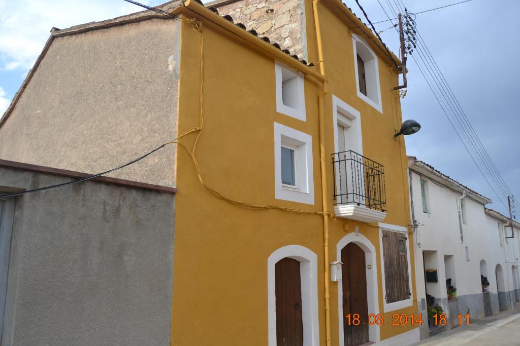 um edifício amarelo com janelas brancas e um telhado em Cal Llorenç em Sant Pere Sacarrera