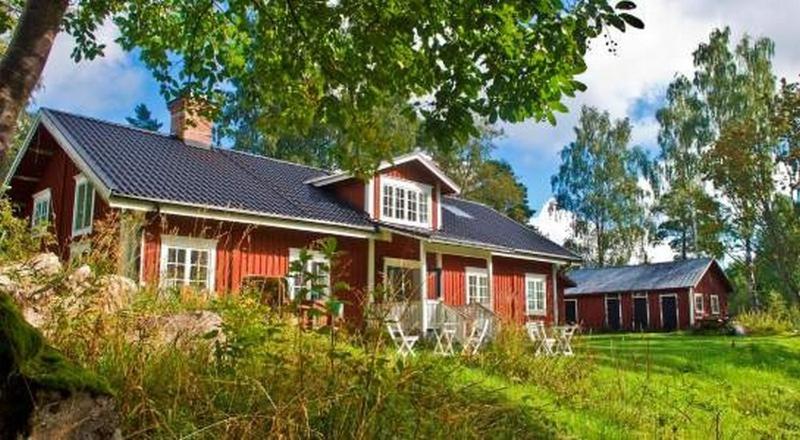 una casa roja con techo negro en STF Kungsgården Långvind, en Enånger