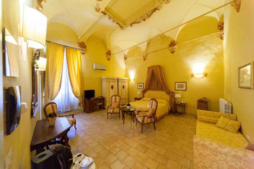 a bedroom with a bed and a table and chairs at Palazzo Guiderocchi in Ascoli Piceno