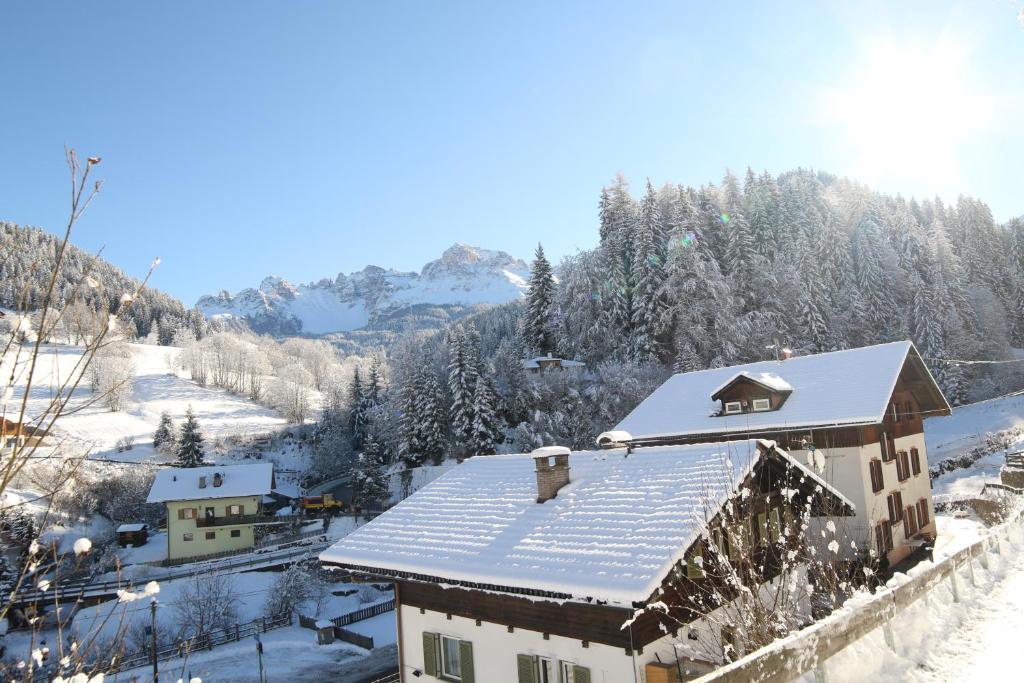 ein Haus mit Schnee auf dem Dach in der Unterkunft Rider Hotel Obereggen in Obereggen