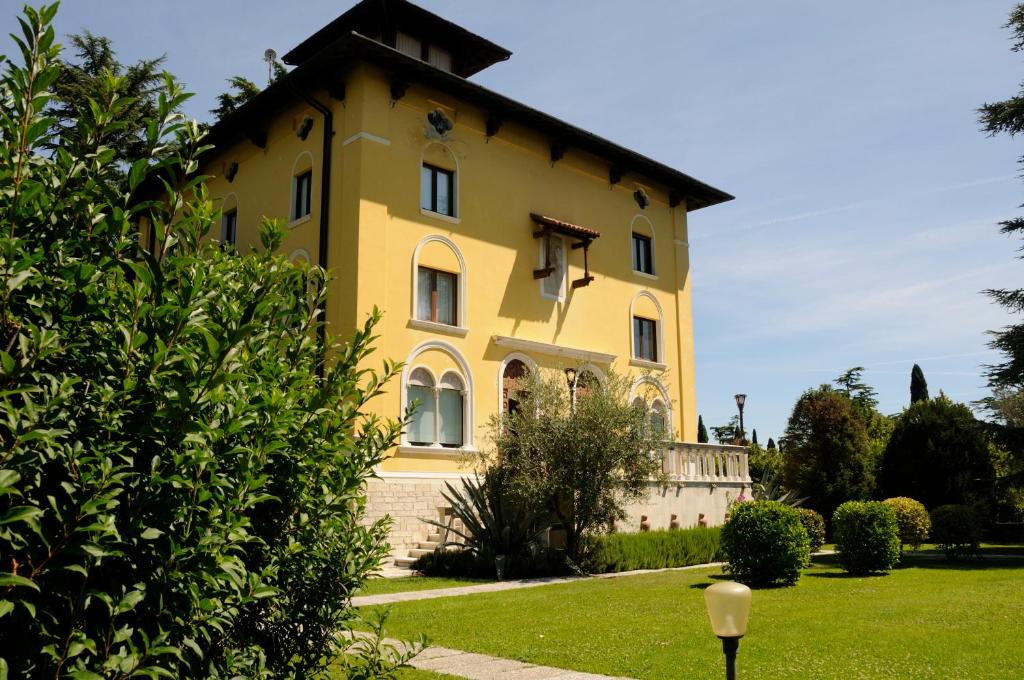 a yellow house with a roof at Villa Maria Callas Sirmione in Sirmione