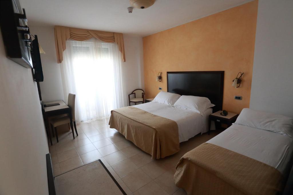 Hotel Du Soleil في ريميني: غرفة فندقية بسريرين ونافذة