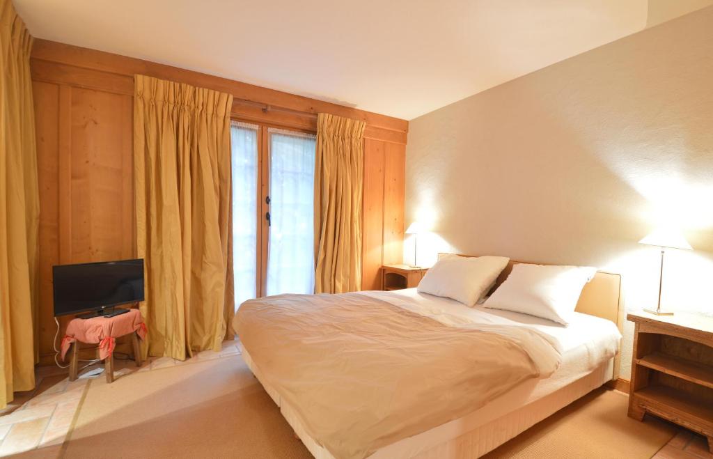 a bedroom with a large bed and a television at Studio Grands Ducs 222 in Verbier