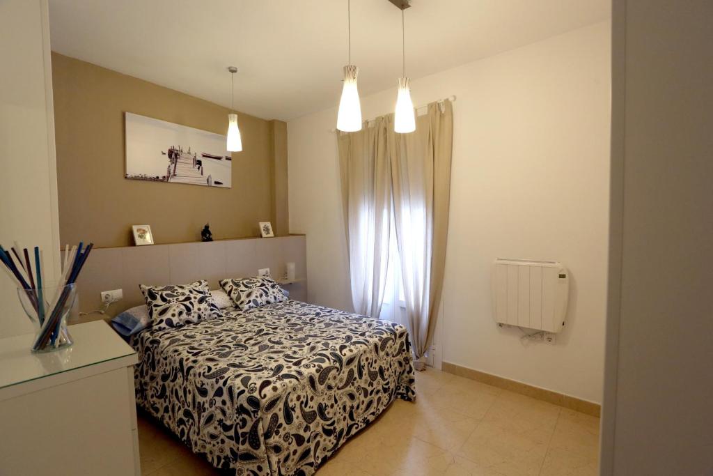 Schlafzimmer mit einem schwarzen und weißen Bett und einem Fenster in der Unterkunft Apartamento Duque de Arcos 2 in Arcos de la Frontera