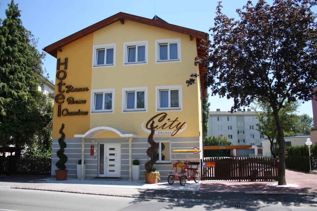 een geel gebouw met een bord aan de zijkant bij City Hotel Neunkirchen in Neunkirchen