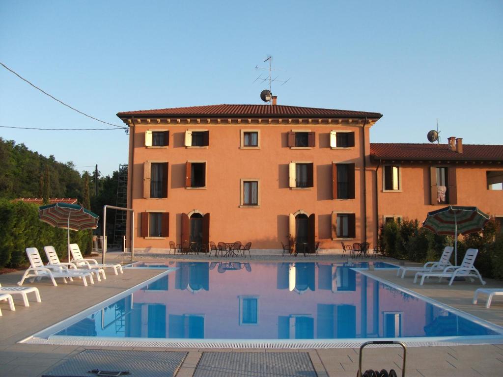 ein großes Gebäude mit einem Pool vor einem Gebäude in der Unterkunft Il Cigno in Valeggio sul Mincio