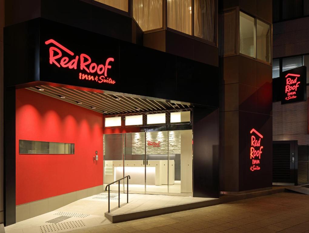 a red roof building with a red sign on it at Red Roof Inn & Suites Osaka Namba Nipponbashi in Osaka