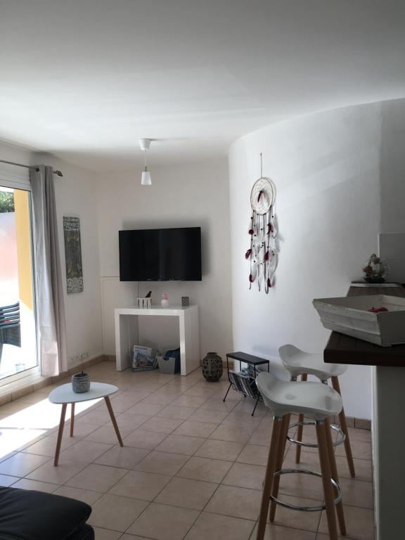 ein Wohnzimmer mit weißen Wänden sowie einem Tisch und Stühlen in der Unterkunft Charmant appartement - Centre d'Arcachon in Arcachon