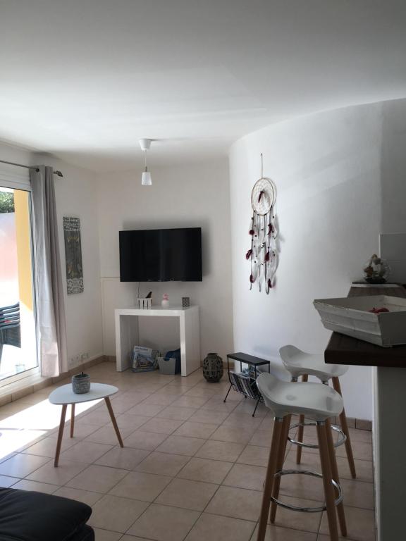 een woonkamer met witte muren en een tafel en stoelen bij Charmant appartement - Centre d'Arcachon in Arcachon