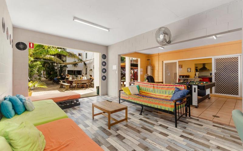 a living room with two beds and a patio at Civic Guesthouse in Townsville