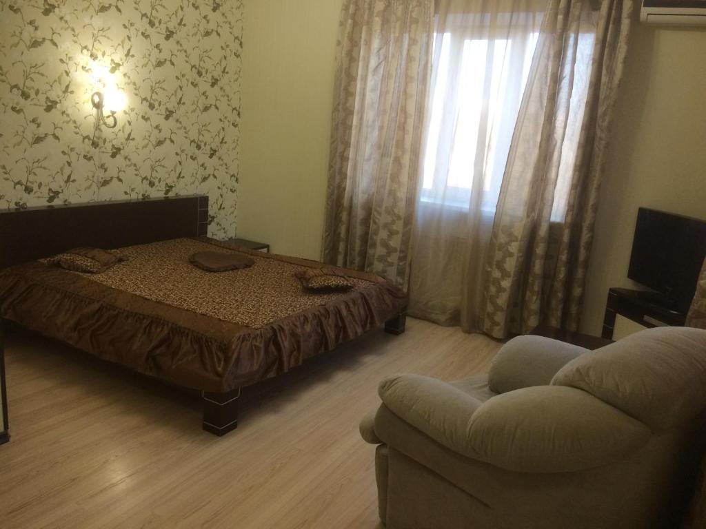 卡爾可夫的住宿－Hotel Grant，一间卧室配有一张床、一张沙发和一把椅子