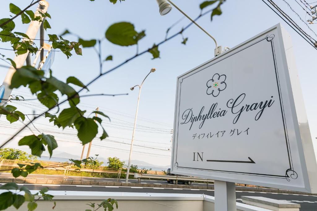 a sign for a cauliflowereryery sign in front of a building at Guest House Diphylleia Grayi in Hatsukaichi