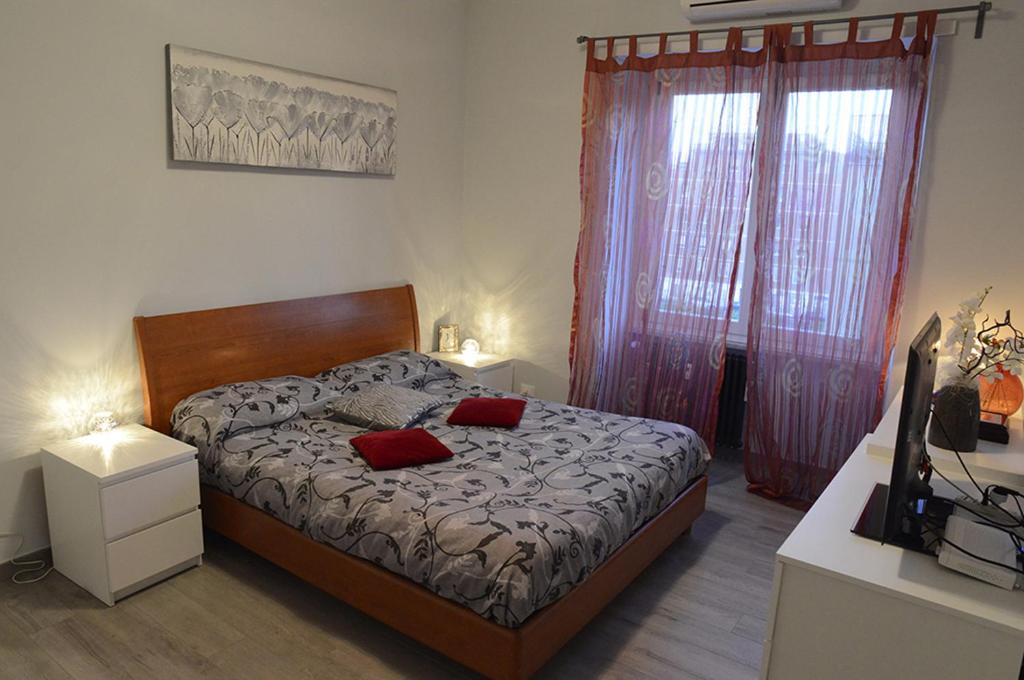 ein Schlafzimmer mit einem Bett mit zwei roten Kissen darauf in der Unterkunft Sweet home Appio Latino in Rom