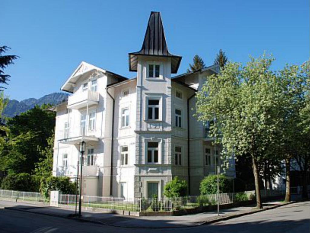 una gran casa blanca con una torre en una calle en King Luitpold Apartment, en Bad Reichenhall