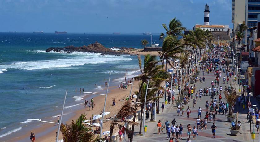 eine Menschenmenge an einem Strand in der Nähe des Ozeans in der Unterkunft Flat no Farol da Barra in Salvador