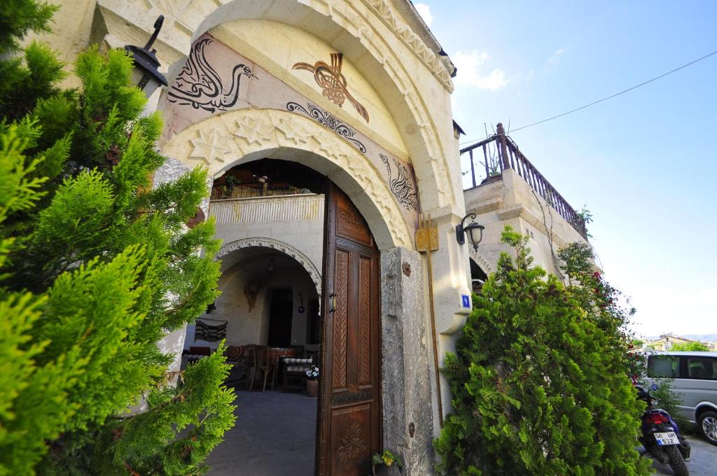 uma entrada para um edifício com uma porta de madeira em Kismet Cave House em Goreme