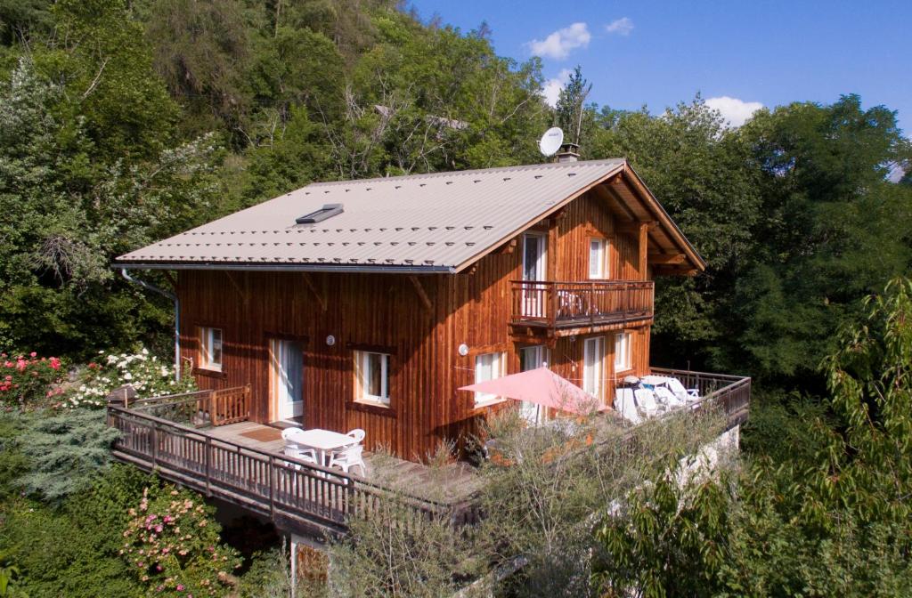 une maison en bois avec un balcon sur une colline dans l'établissement La Ressource, à Villars-Colmars