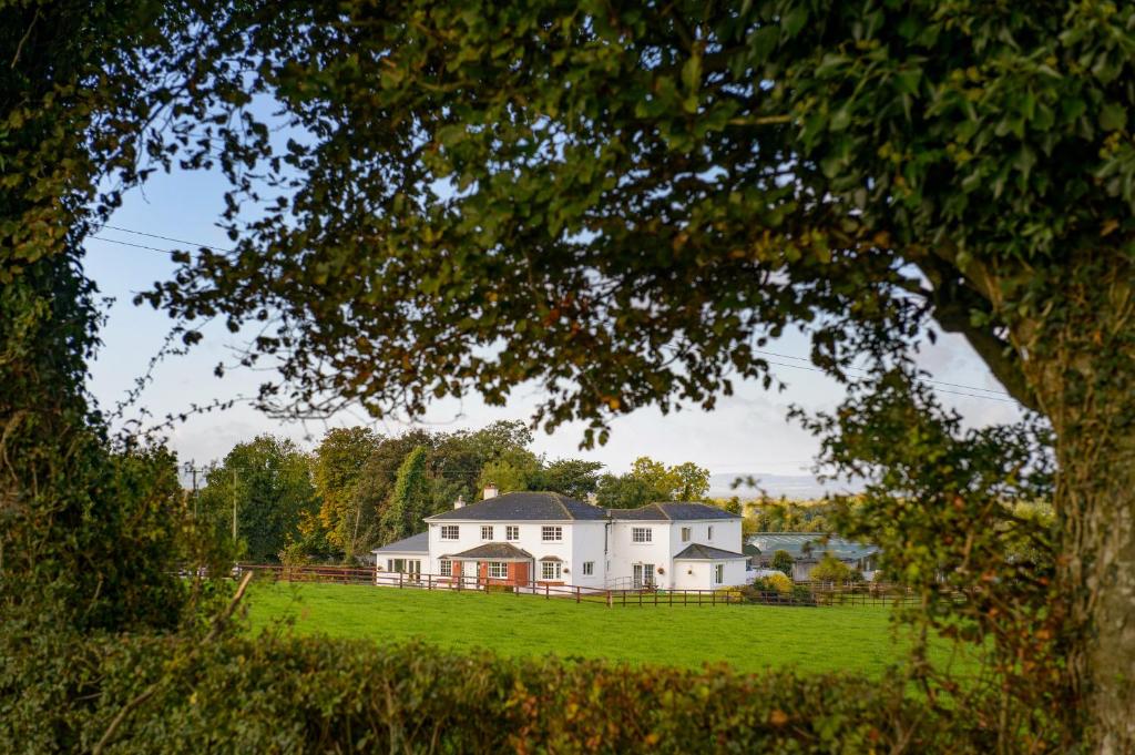 ein großes weißes Haus auf einem grünen Feld in der Unterkunft Ballindrum Farm B&B in Athy