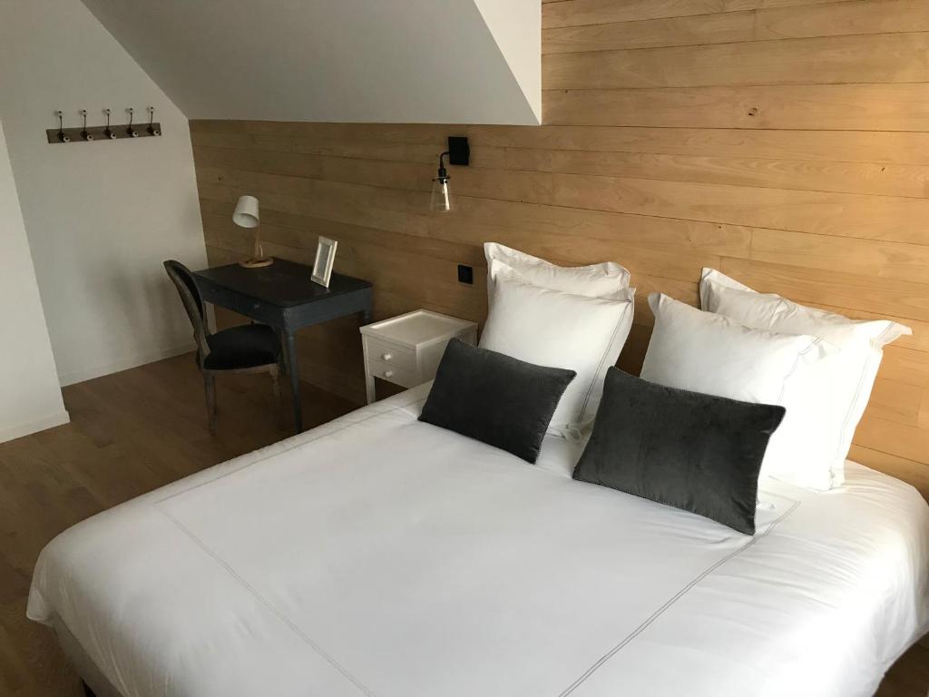 a white bed with four pillows and a desk at Chambres d&#39;hôtes Saint Jean in Nogent-le-Rotrou