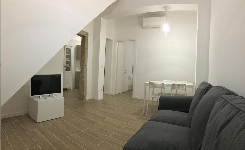 uma sala de estar com um sofá e uma televisão em Ca' Lucia Apartment em Veneza