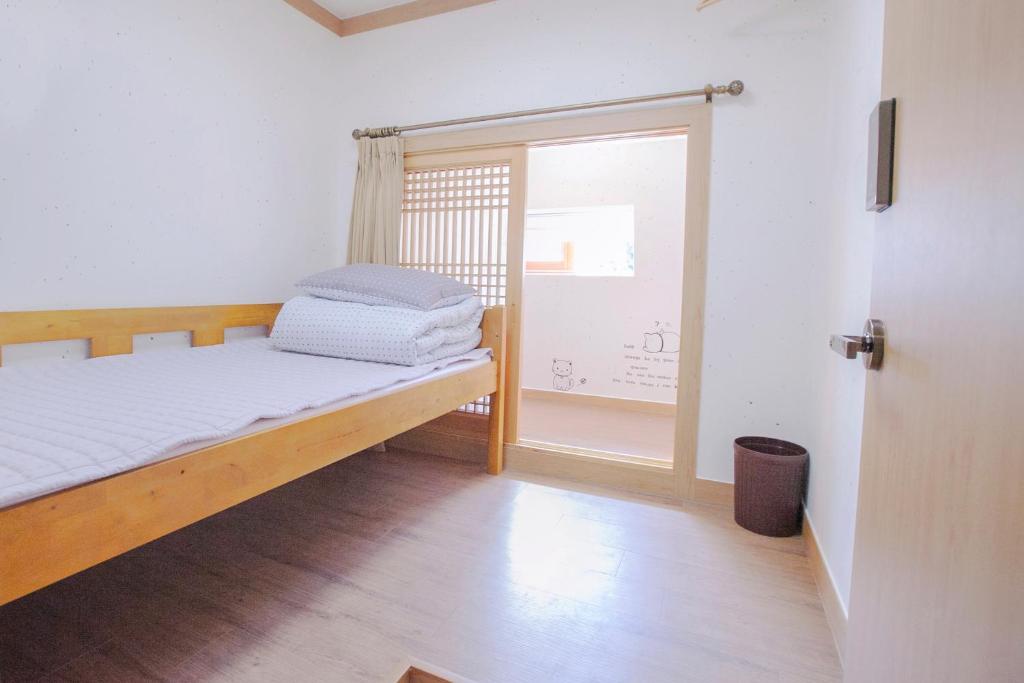 a bedroom with a bed and a window at Cocoa Guesthouse in Seoul