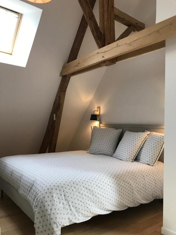 a bedroom with a large white bed with wooden beams at Chambres d&#39;hôtes Saint Jean in Nogent-le-Rotrou