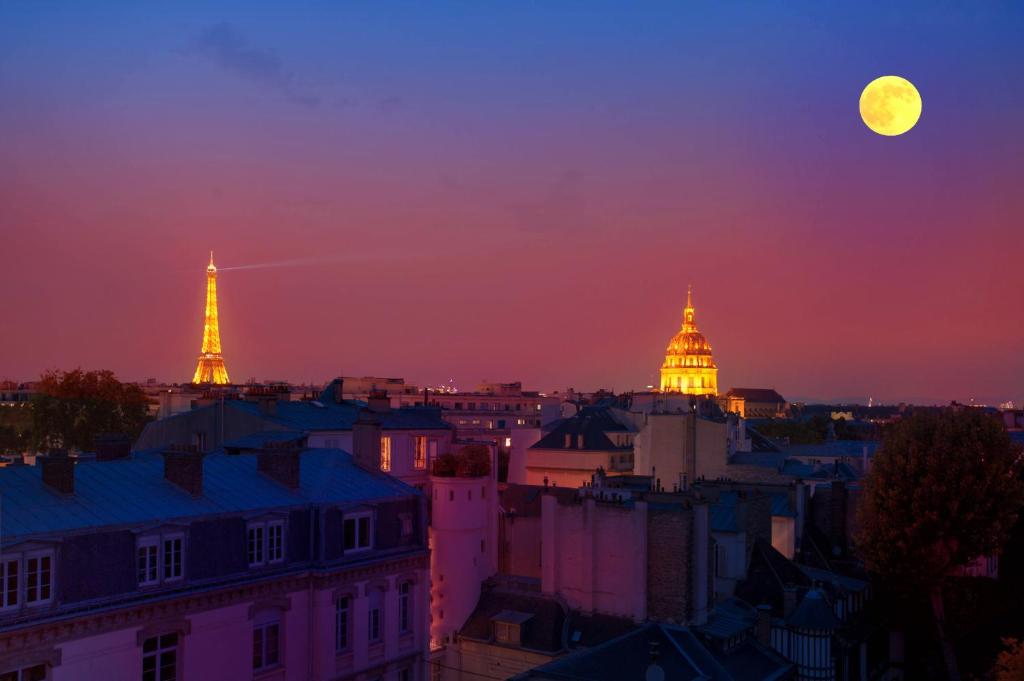 Blick auf eine Stadt bei Vollmond in der Unterkunft Eiffel Tower view + terrace Saint Germain des Pres in Paris