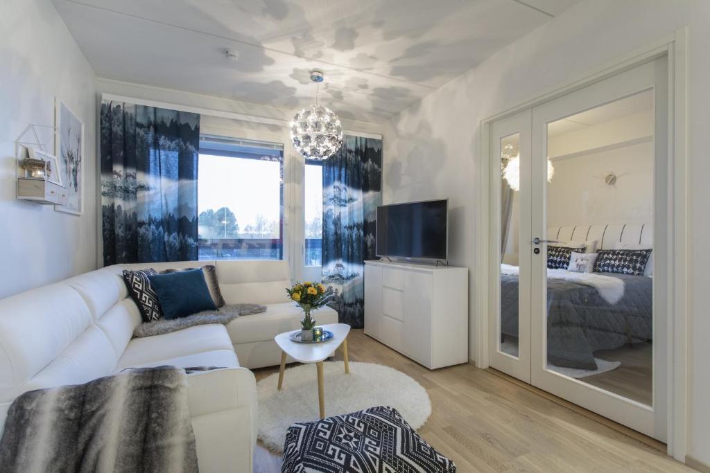 a living room with a white couch and a bedroom at Vasko Luxurious Suites, Nilo in Rovaniemi