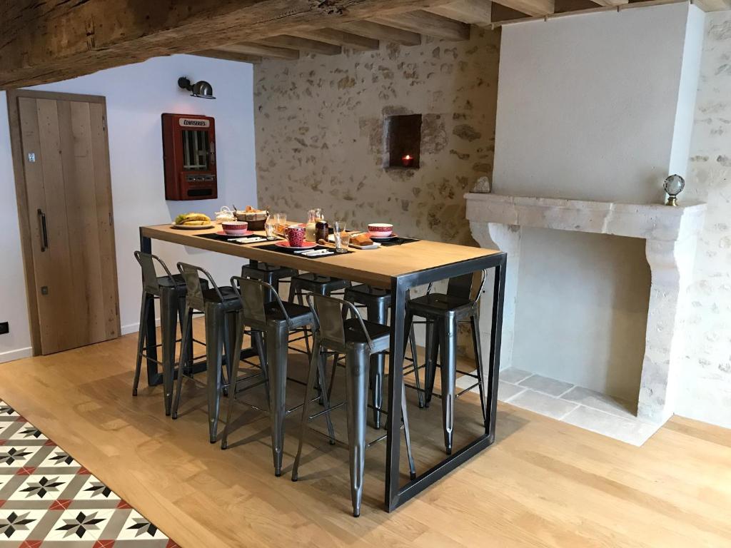 a kitchen with a table and stools in a room at Chambres d&#39;hôtes Saint Jean in Nogent-le-Rotrou