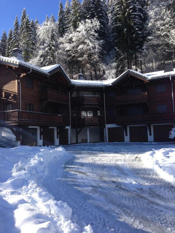 un grand bâtiment avec de la neige au sol dans l'établissement La combe, à Morzine