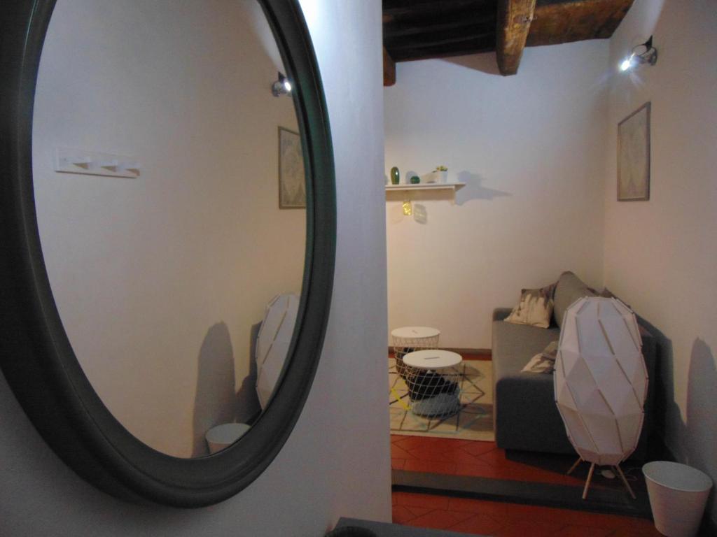 a mirror on a wall next to a living room at Gessi Charming Apartments in Florence