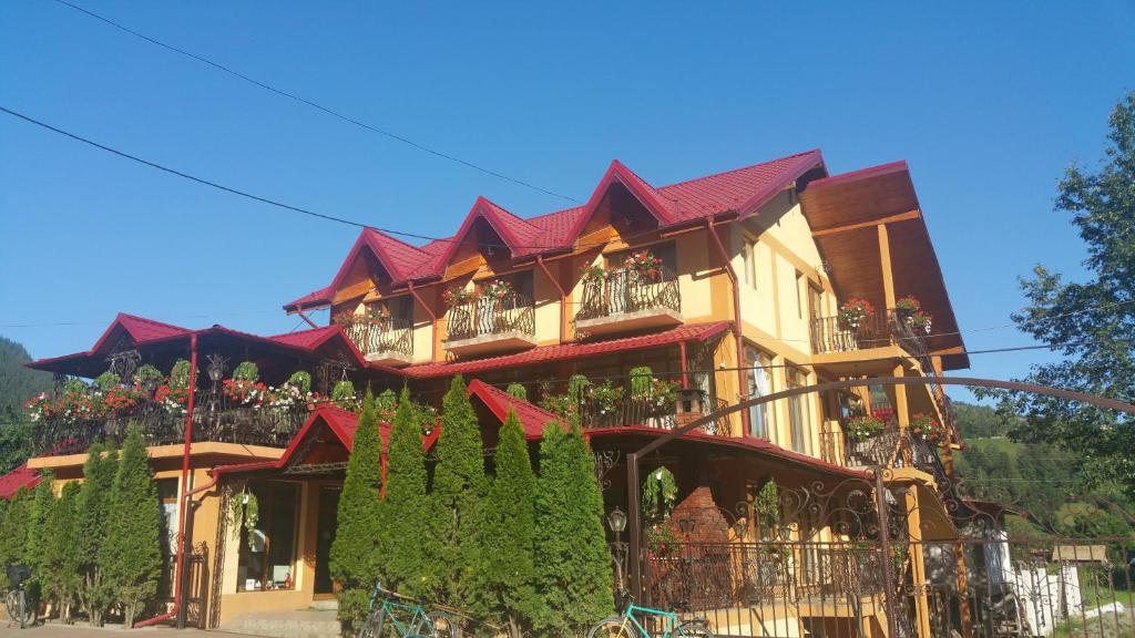 een groot gebouw met balkons en planten erop bij Pensiunea Rozmarin in Borca