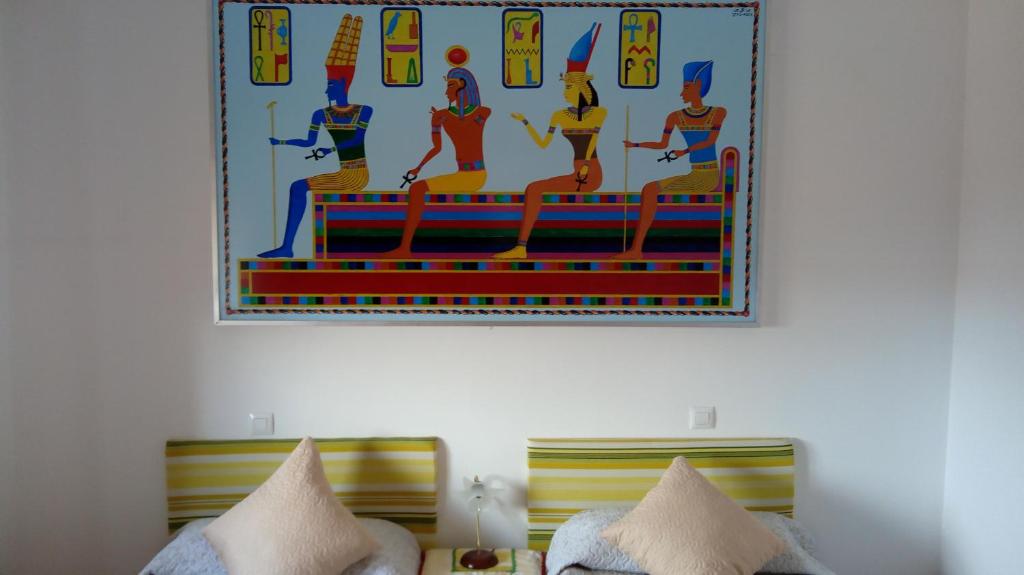 una foto sulla parete di una camera con due letti di Casa Rural Egipto Parque Puy Du Fou a 12 kilómetros a Guadamur