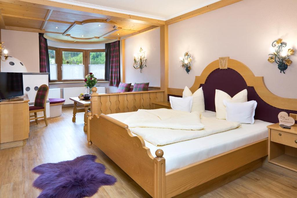 a bedroom with a large bed with a purple rug at Hotel "Zum Ritter" in Tannheim