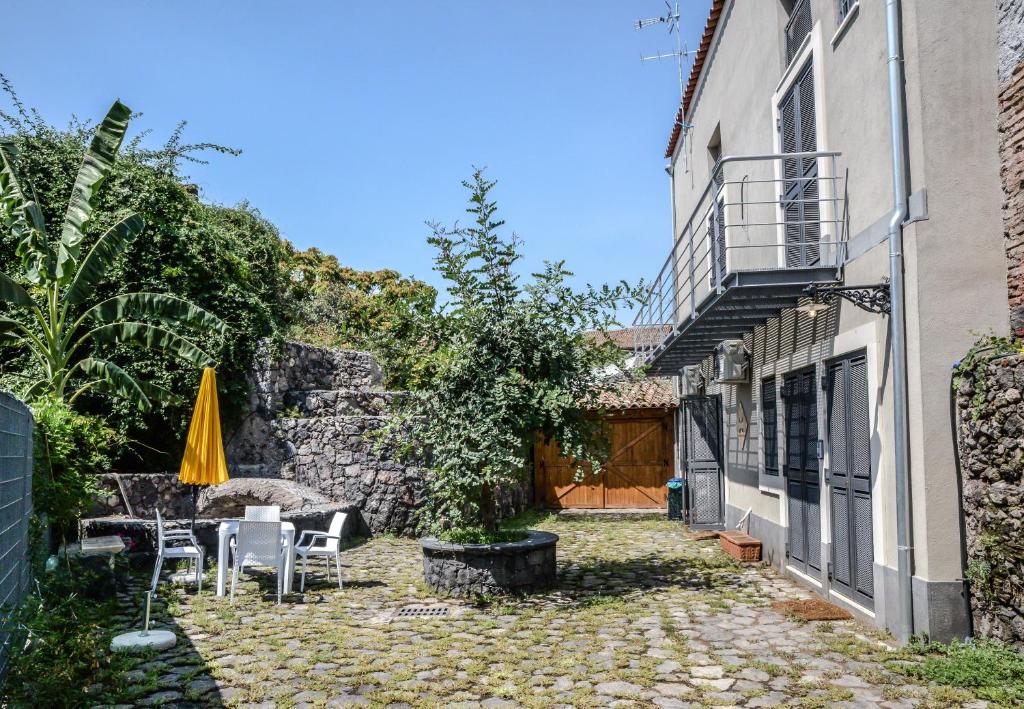 een patio met stoelen en een parasol naast een gebouw bij Case Vacanze - Antico Corso in Catania