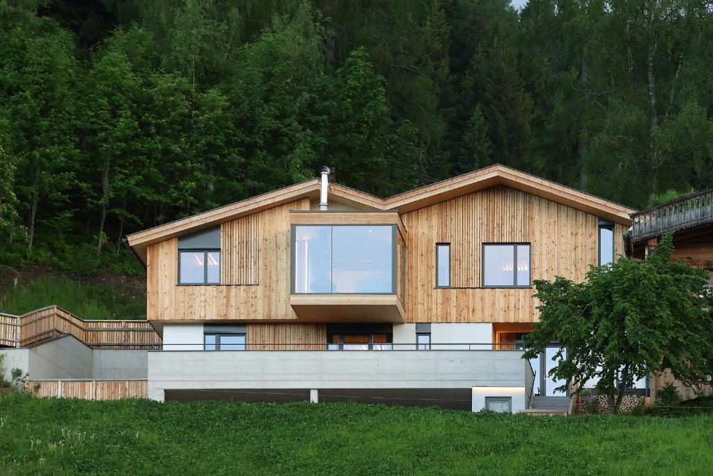 a house with a wooden facade on a hill at Chalet Alm Planai in Schladming