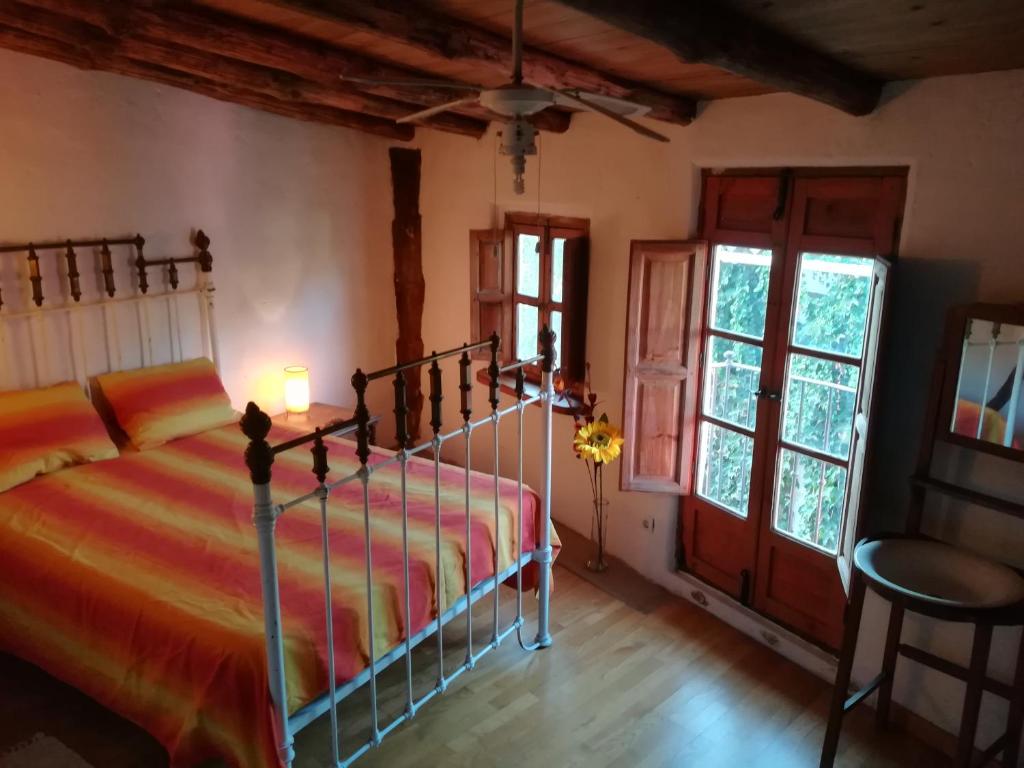 a bedroom with a bed in a room with windows at Casa Farfarnicola in Aguafría