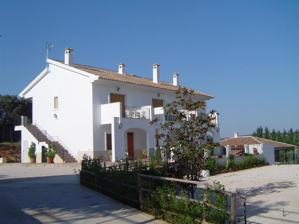 a white house with a fence in front of it at Apartamentos el Volapie in Montemayor