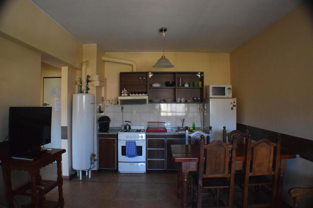 - une cuisine avec des appareils électroménagers blancs, des tables et des chaises dans l'établissement Departamento centrico, à Mendoza