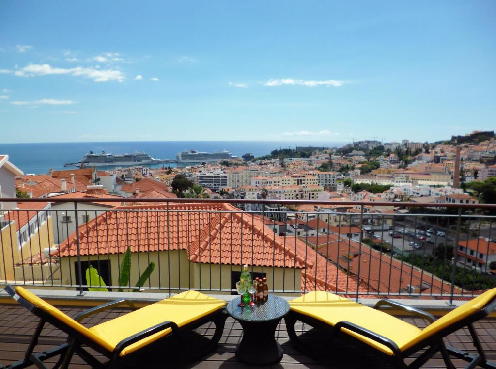 フンシャルにあるLuxury Apartment Living Funchalのバルコニー(椅子2脚、屋上テーブル付)