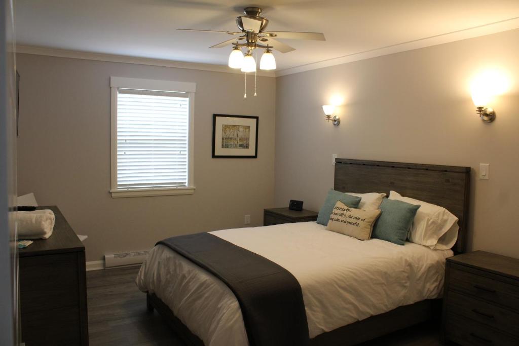 a bedroom with a bed and a ceiling fan at Cape Breton Villas in Inverness