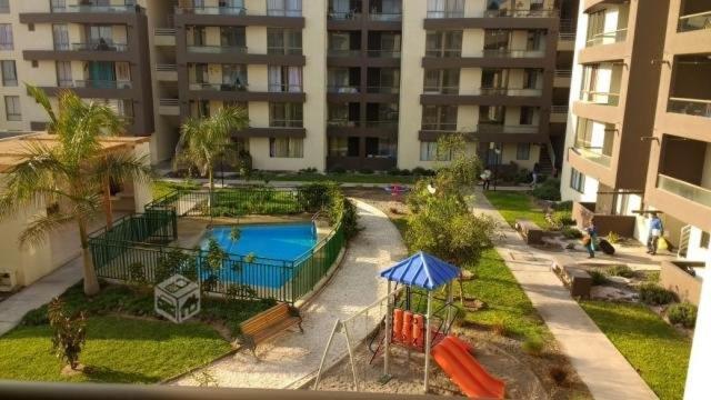 阿里卡的住宿－Departamento arica，公寓大楼设有游泳池和游乐场。