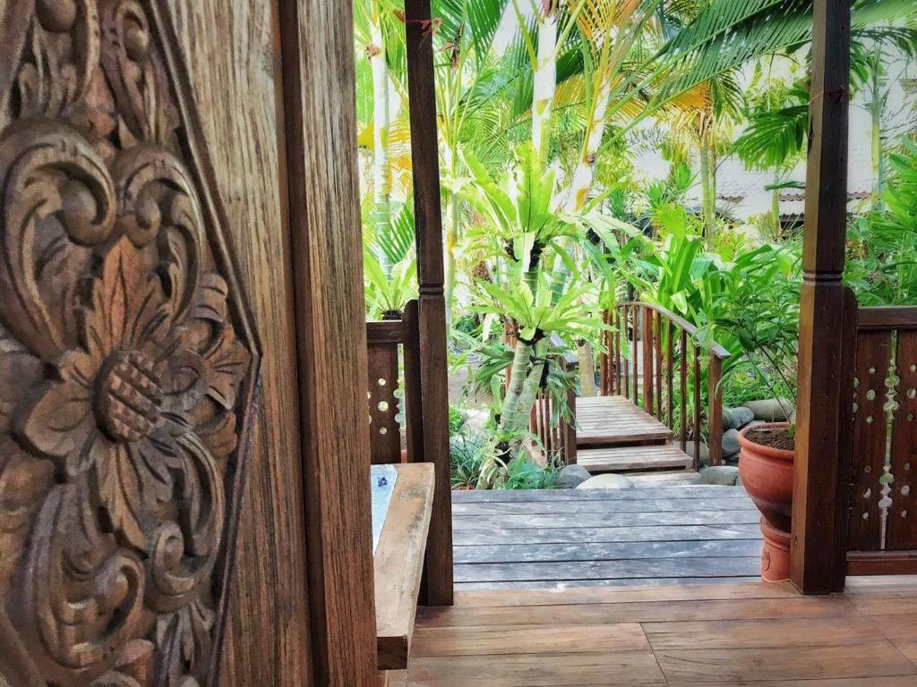 una entrada a una casa con una puerta de madera en Melati Bali Homestay, en Canggu