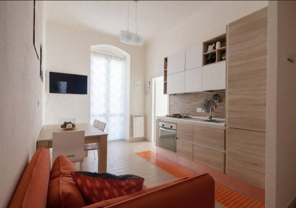 Il dispose d'une cuisine et d'un salon avec un canapé et une table. dans l'établissement Glad Apartment, à La Spezia