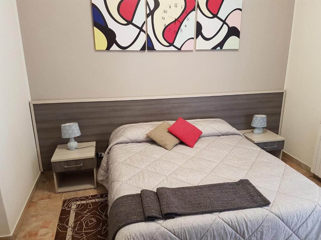 a bedroom with a bed with two tables and a painting at B&B Monté in Montesilvano