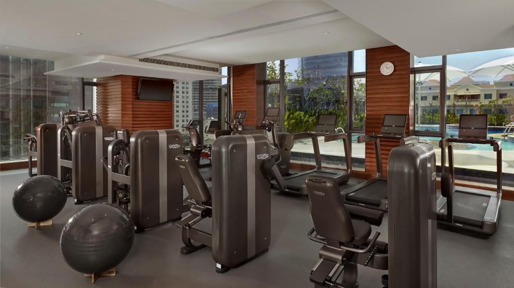 a gym with a lot of treadmills and ellipticals at The Reverie Saigon in Ho Chi Minh City