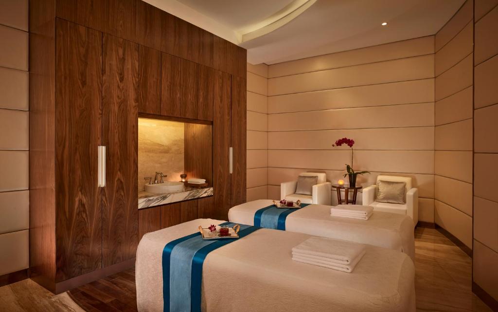 a room with two beds and a sink in it at The Reverie Saigon in Ho Chi Minh City
