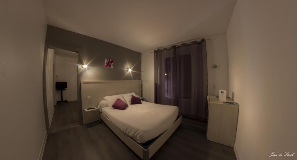 Postel nebo postele na pokoji v ubytování Logis Hôtel Le pont d'Arcole