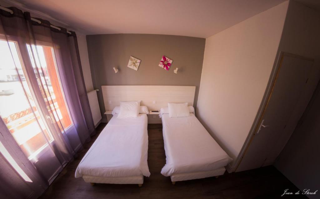 Postel nebo postele na pokoji v ubytování Logis Hôtel Le pont d'Arcole